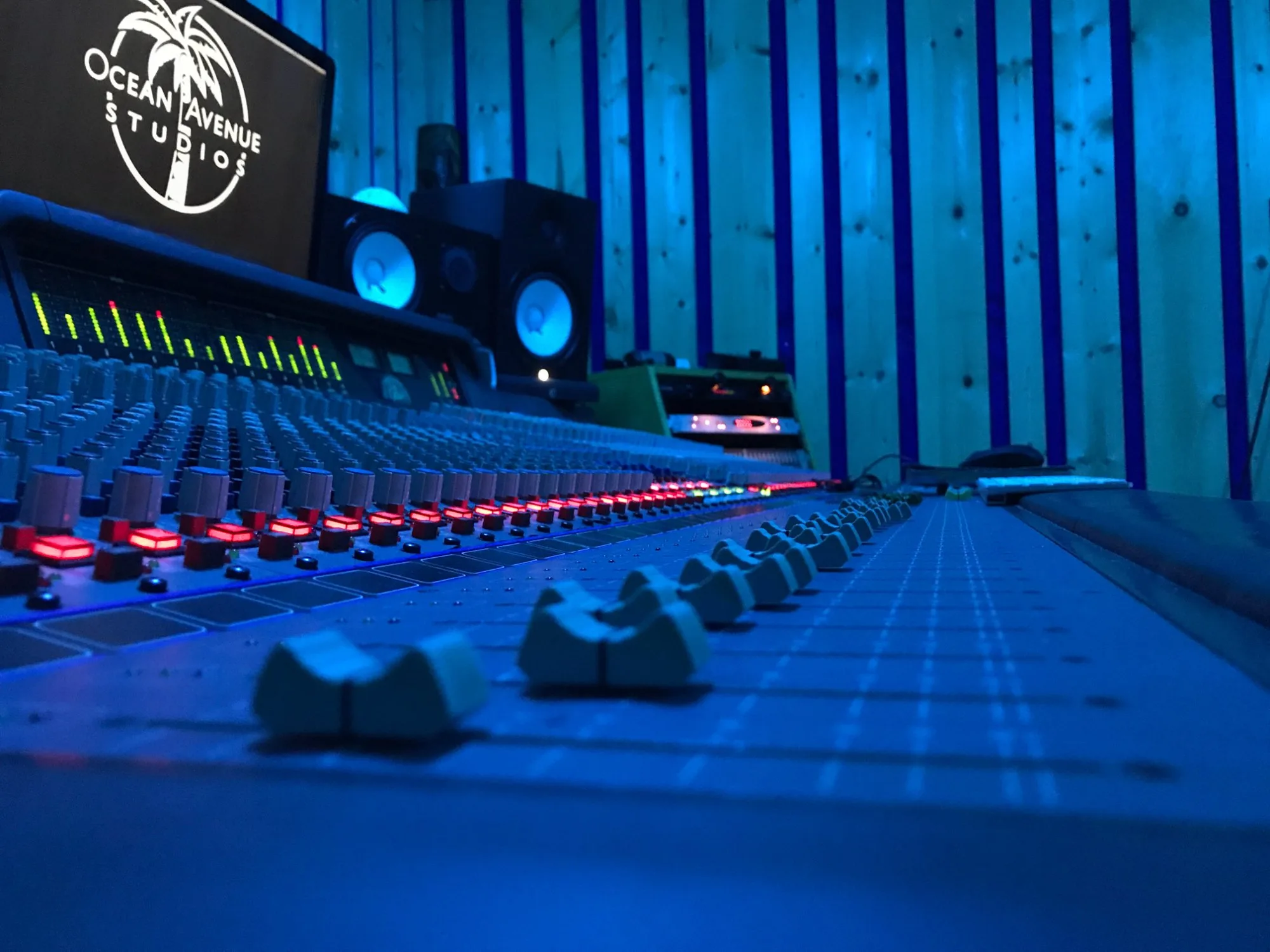 Mixing console faders in blue studio lighting